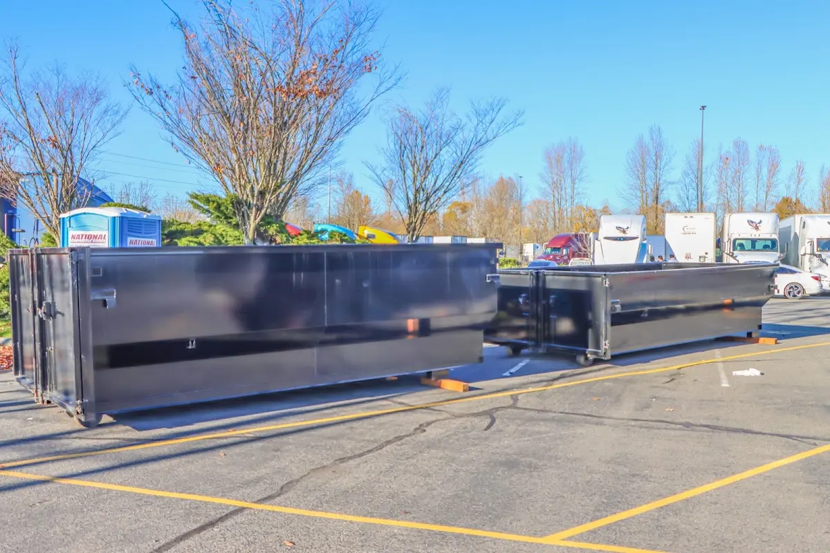 Professional dumpster rental service with roll-off container on residential driveway in Grand Terrace